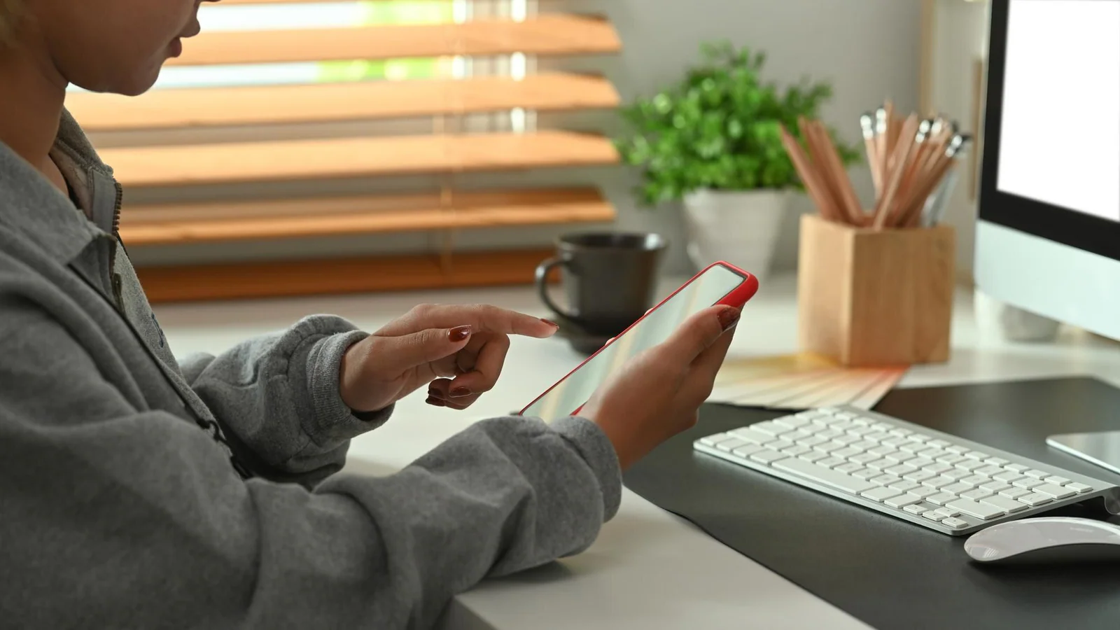 Person vid dator och mobiltelefon som illustrerar arbete med färre digitala avbrott