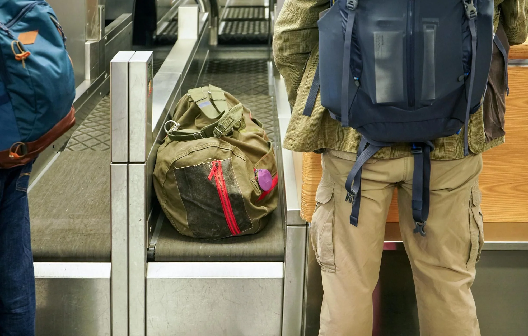 Passagerare med bagage vid flygplatsens incheckningsdisk inför kontroll av handbagage och bagageregler