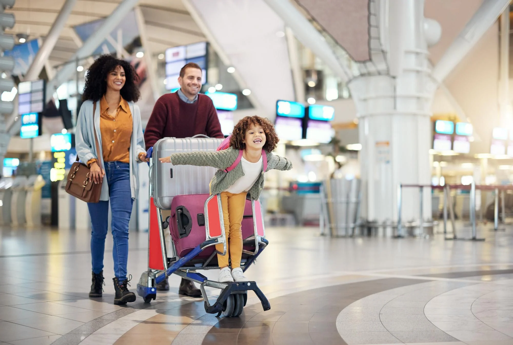 Familj med barn och resväskor på flygplats inför gemensam flygresa