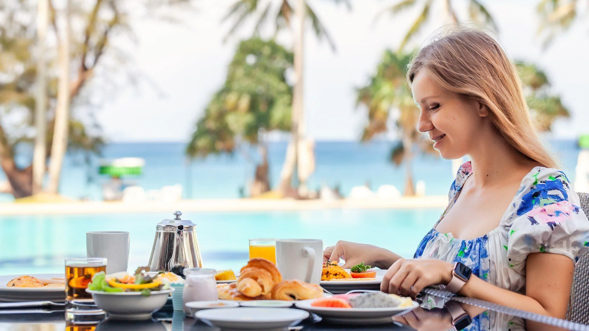 Frukost vid resortpool med havsutsikt som illustration till en all-inclusive-semester