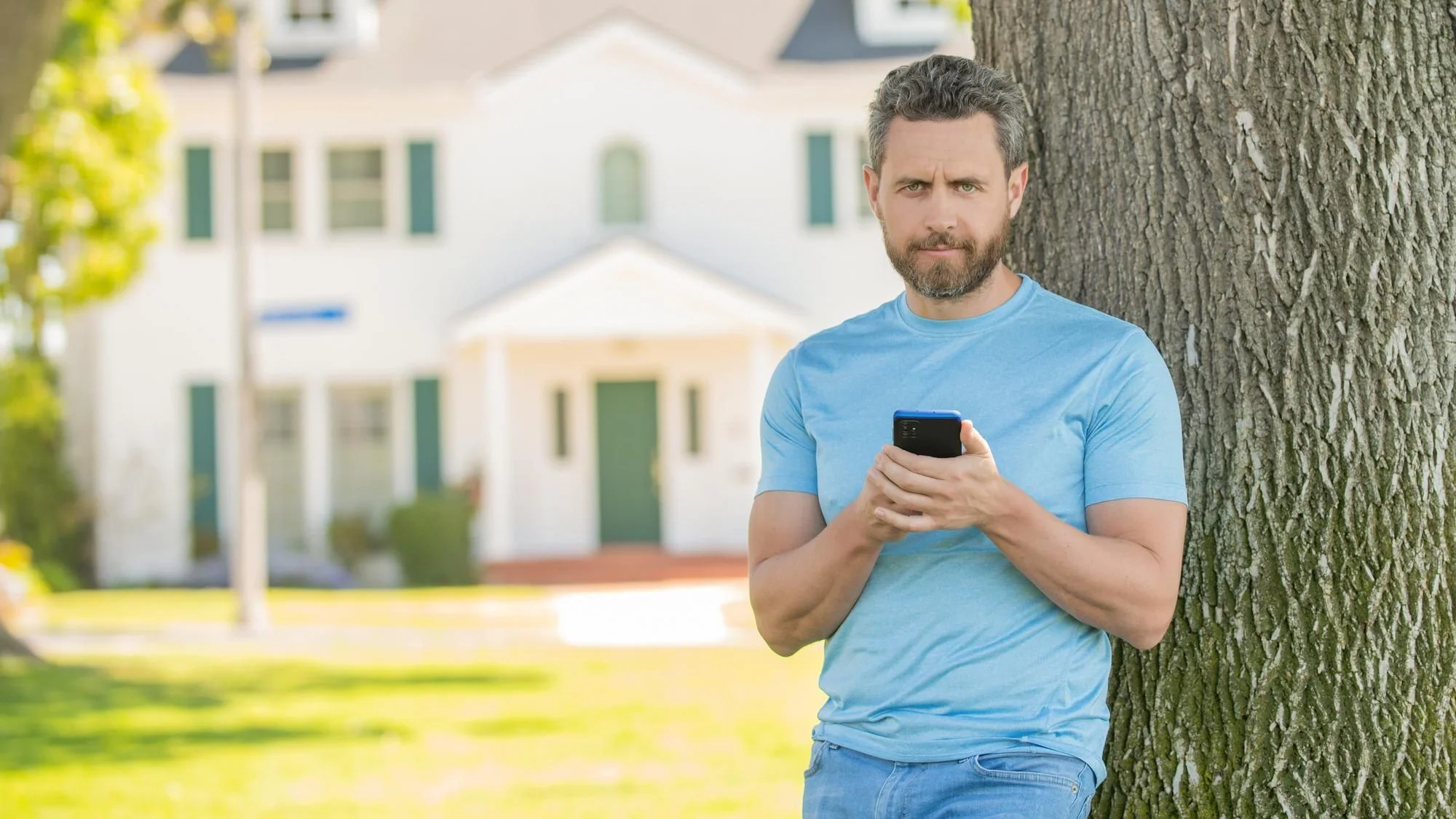 Fastighetsmäklare använder smartphone för digital bostadsförmedling och kontakt med kunder